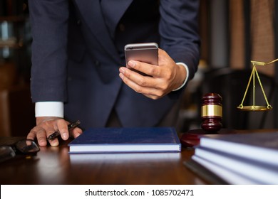 Business Lawyers Using Cell Phone For Contact Customer With Brass Scale On Wooden Desk In Office. Law, Legal Services, Advice, Consult, Justice Concept.