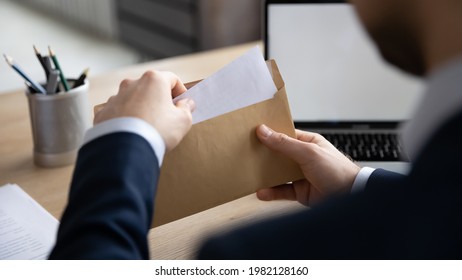 Business leader, executive, CEO receiving letter, invitation, notification, postcard at workplace, opening envelope with blank paper, taking out document for reading. Mail service concept. Close up