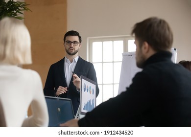 Business leader presenting project to colleagues or partners. Mentor teaching employees, explaining marketing report analysis. Coach giving presentation to interns. Presenter speaking before staff