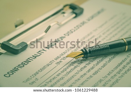 Business legal document concept : Fountain pen on a confidentiality and non disclosure agreement form. Confidentiality agreement is a legal contract between 2 parties that outlines confidential issues