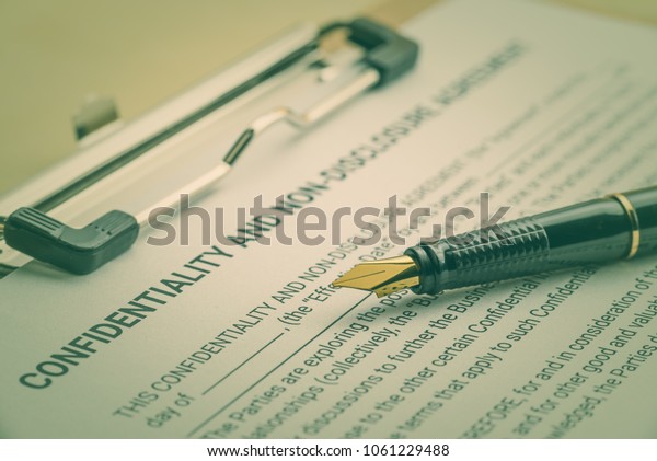 Business legal document concept : Fountain pen on\
a confidentiality and non disclosure agreement form.\
Confidentiality agreement is a legal contract between 2 parties\
that outlines confidential\
issues