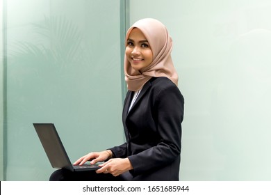 Business Lifestyle, Cute Malay Woman wearing hijab outdoor using laptop sitting on the bench