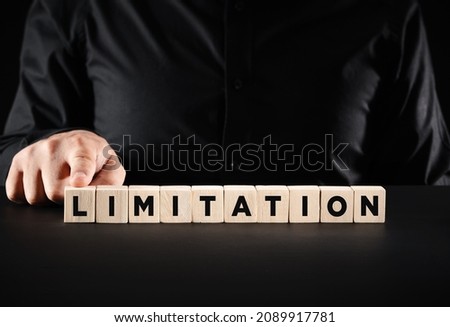 Business limitation or boundaries concep. Businessman presses the wooden cubes with the word limitation.