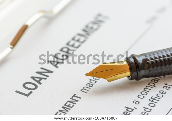 Business loan agreement or legal document\
concept : Fountain pen on a loan agreement paper form. Loan\
agreement is a contract between a borrower and a lender, a\
compilation of various mutual\
promises.