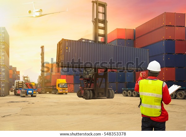 Business logistic\
concept, Foreman control loading Containers box to truck for\
Logistic Import Export\
Background