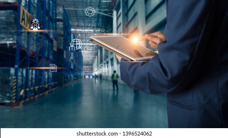 Business Logistics Konzept, Geschäftsmann Manager mit Tablet-Check und-Kontrolle für Mitarbeiter mit moderner Warenlager-Logistik. Konzept der Industrie 4.0
