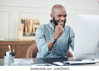 Business is looking great. Shot of a handsome young businessman sitting alone in his office and celebrating a success while using his computer.