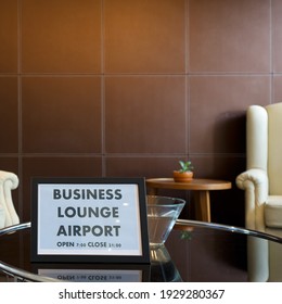 The Business Lounge Airport Service Time Sign Is Placed On A Modern Round Tempered Glass Table.