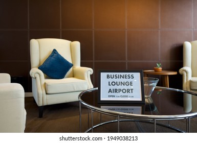 The Business Lounge Airport Service Time Sign Is Placed On A Modern Round Tempered Glass Table.