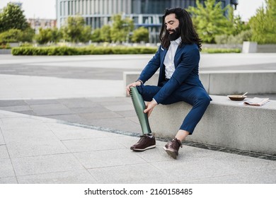 Business Man Adjusting His Prosthetic Leg Outdoor From Office Building - Focus On Hands Holding Prosthesis