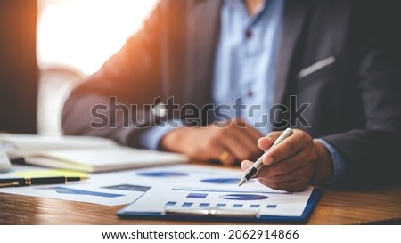Business man analyzing the business price chart on the desk at the meeting room in the morning
