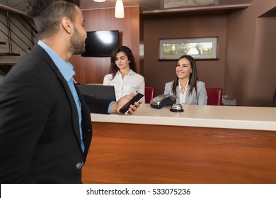 Business Man Arrive To Hotel Check In With Cell Phone Woman Receptionist Registration At Reception Counter