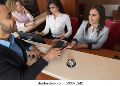 Business Man Arrive To Hotel Check In With Cell Phone Woman Receptionist Registration At Reception Counter