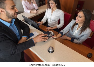 Business Man Arrive To Hotel Check In With Cell Phone Woman Receptionist Registration At Reception Counter