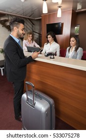 Business Man Arrive To Hotel Check In With Cell Phone Woman Receptionist Registration At Reception Counter