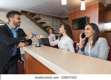 Business Man Arriving To Hotel Give Meeting Woman Receptionist Credit Card Pay Room Registration At Reception Counter Checking In