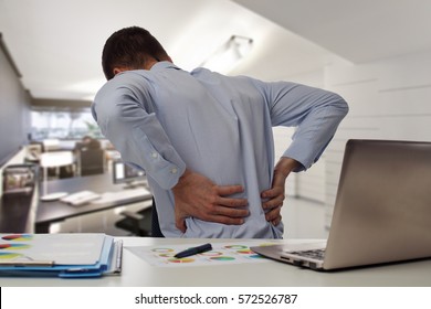 Business man with back pain an office . Pain relief concept