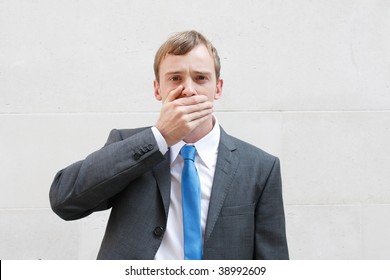 A Business Man Being Silent, Holding A Hand Over His Mouth