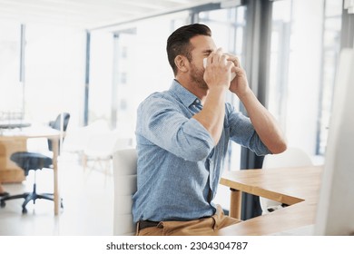 Business man, blowing nose and allergy in office with flu, virus and tissues for healthcare at desk. Young businessman, allergies or sick with hayfever, toilet paper and cleaning mucus in workplace