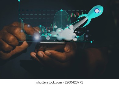 Business man and blue rocket flying in space.A man use mobile phone showing hologram stock. fast growing business,save money,investment,bank,finance,Photo financial saving and Startup Concept. - Shutterstock ID 2200423771