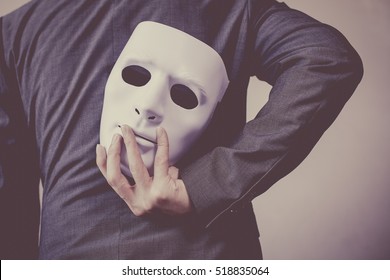 Business man carrying white mask to his body indicating Business fraud and faking business partnership