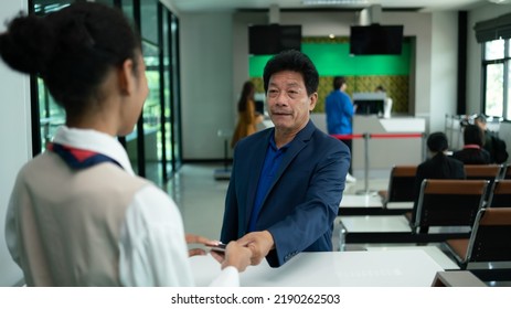 Business Man At Check-in Counter With Airlines Staff. Airline Transportation And Tourism Concept.