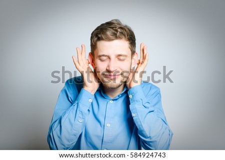 Business man closes his ears isolated on a gray background