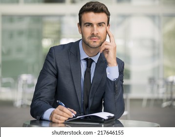 Business man concentrating on paperwork and finance writing and in thought confident and brainstorming in a suit