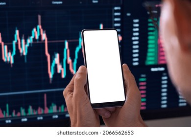 Business man crypto trader investor analyst holding cell phone white mockup screen template doing stock market data charts graphs analysis using cryptocurrency trading mobile app. Over shoulder view - Shutterstock ID 2066562653