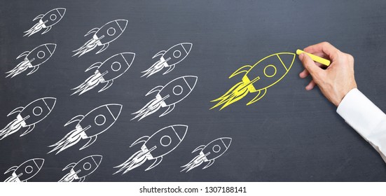 Business Man Is Drawing Yellow Rocket On Blackboard With Chalk. Rising Concept