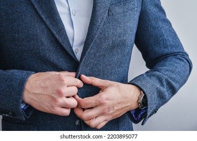 Business Man Fastens A Button On Blue Tweed Blazer, Hands Close-up.