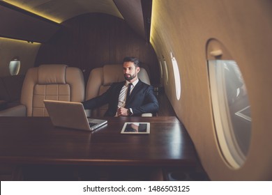 Business Man Flying On A Private Jet. Working Onboard Of The Airplane. Successfull Businessmen Lifestyle. Concept About Traders, Affiliate Marketing And Sales People