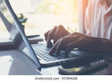 Business Man Or Freelancer Working On Laptop Computer On White Desk With Smart Phone And Books At Home Office, Close Up, Online Working, Internet Of Things Concept