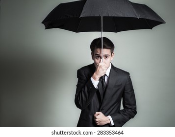 Business Man With Funny Expression Holding An Umbrella. 