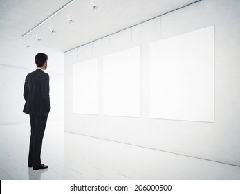 Business Man In Gallery Room Looking At Empty Frames