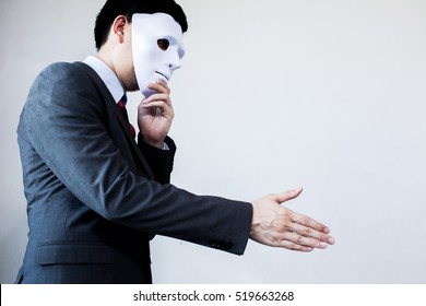 Business Man Giving Dishonest Handshake Hiding In The Mask - Business Fraud And Hypocrite Agreement.