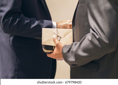 Business Man Giving A Gift With Envelope And Shaking Hands