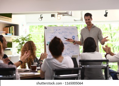 Business Man Giving Presentation On Future Plans To His Colleagues At Office