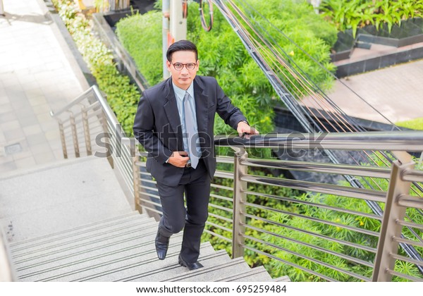 Business man going up the stairs  in a rush hour to\
work. Hurry time.
