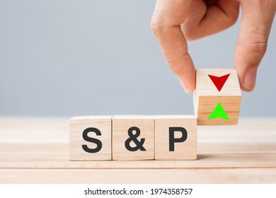 business man Hand change wood cube block with SP text to UP and Down arrow symbol icon. Interest rate, stocks, financial, ranking, mortgage rates and Cut loss concept