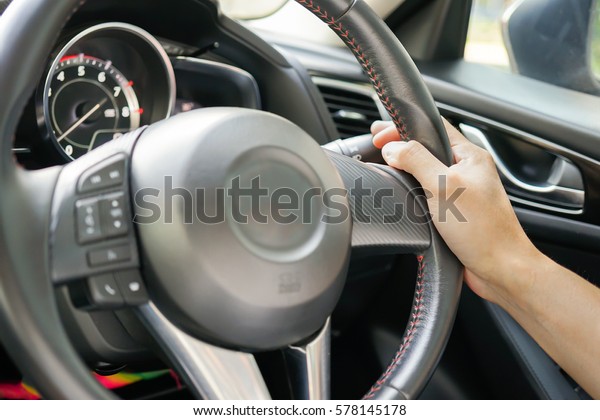 A business man hand driving car on day\
time for safety usage. (take photo from inside focus on driver\
hand), Safe and self Driving background\
concept