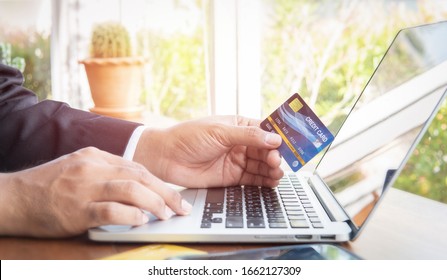 Geschäftsmann Hand halten Kreditkarte zum Einkaufen Internet-Rechnung auf dem Computer, Debit sparende Kauf kaufen auf Tischhintergrund. Shopaholische Privatkunden zahlen Geld, Bankterminal-Account-Konzept
