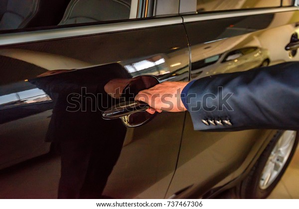 Business man hand holding\
car doorhandle