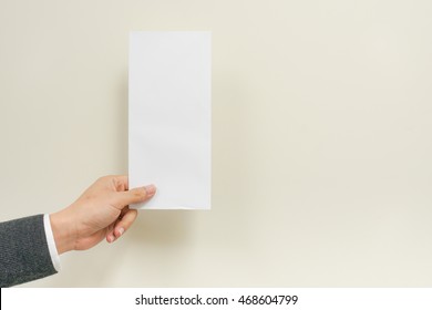 A Business Man Hand Holding White Blank Envelope On White Background With Copyspace. Empty Post Document Design Mockup, Postcard Template For Business Background Concept