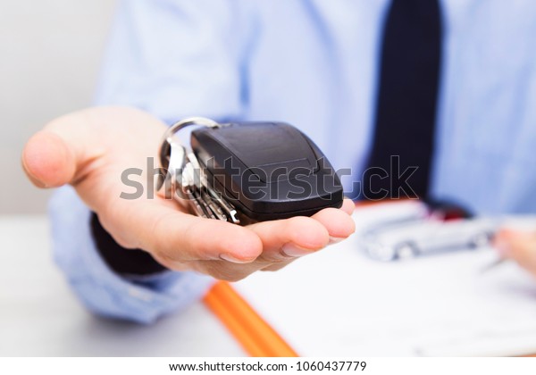 business man hand with\
keys and car control