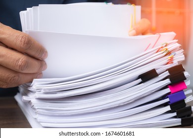 Business Man Hand Pick Up Stack Overload Document Report Paper With Colorful Paperclip, Business And Paperless Concept.