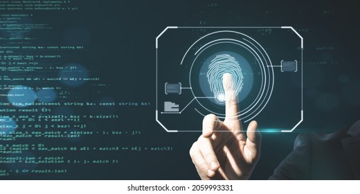 Business man hand pointing at glowing finger print interface on dark background with coding language. Security and biometrics concept