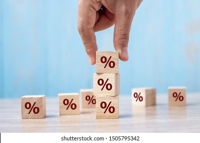 business man Hand putting wood cube block with percentage symbol icon. Interest rate,  financial, ranking and mortgage rates concept