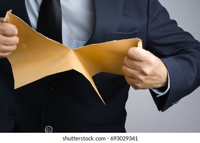 Business Man Hand Tearing Self Sealing Brown Envelope Document In Anger On White Background