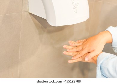 A Business Man Hand Using Air Dryer In Public Toilet Or Washrooms. Selective Focus Health And Safety Background Concept